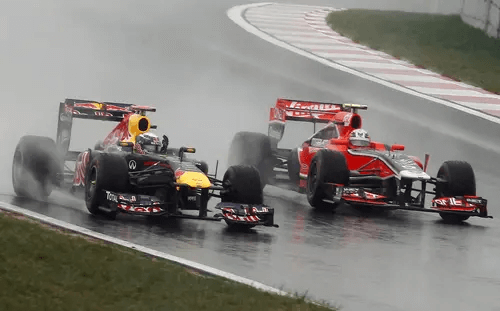 Болиды Формулы 1 на мокром треке под дождём